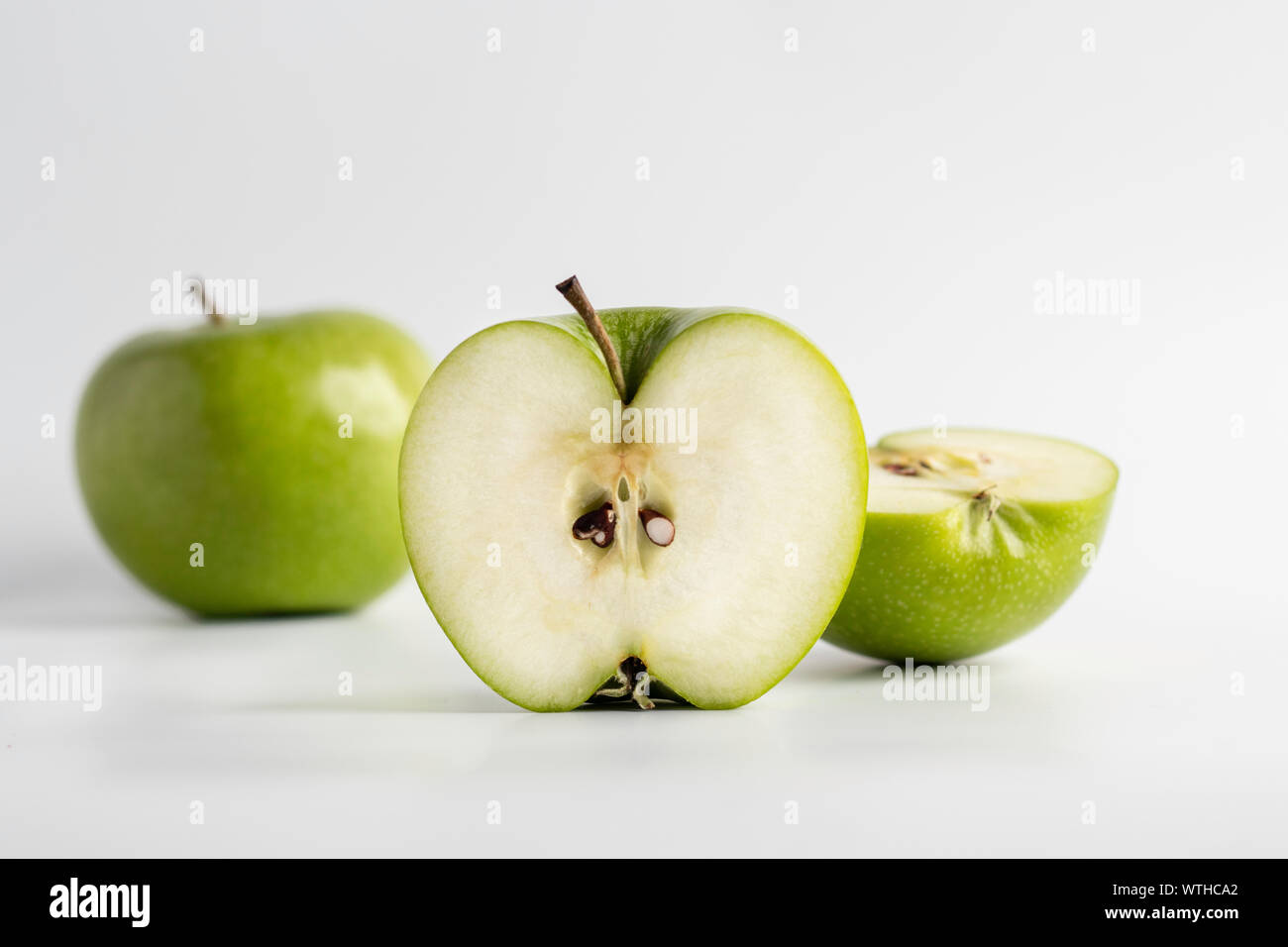 Fresh cut green apple over a white background, closeup Stock Photo