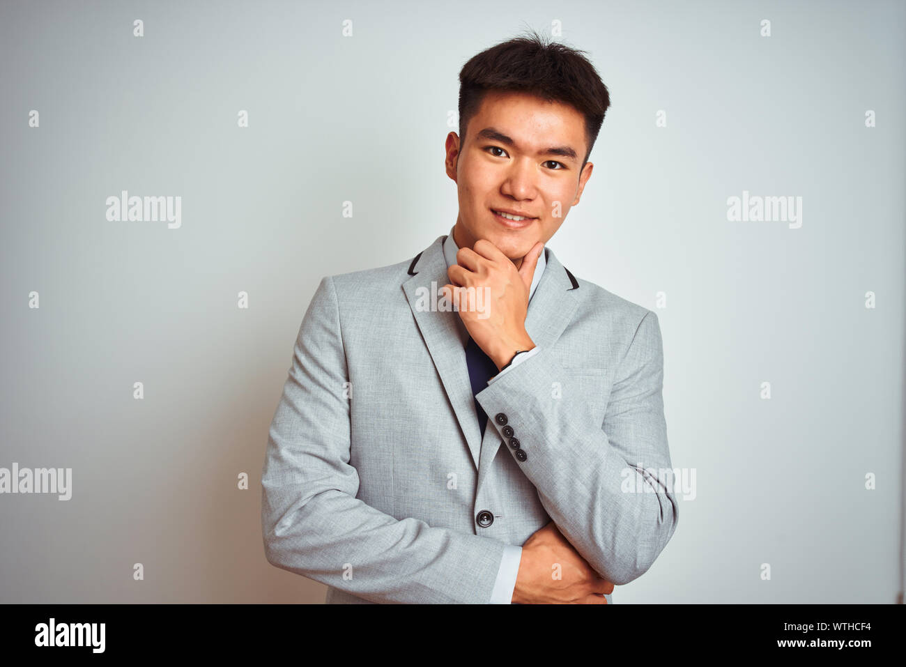 Asian chinese businessman wearing suit and tie standing over isolated ...