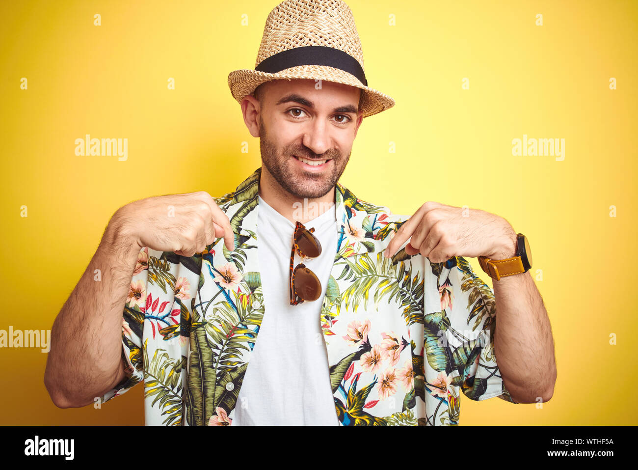 Young man on vacation wearing hawaiian flowers shirt and summer hat ...