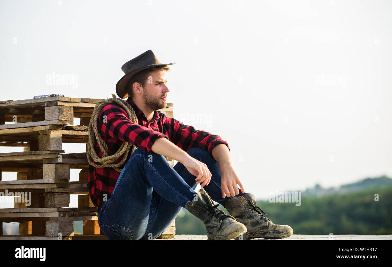 Watching sunset. Farmer cowboy handsome man relaxing after hard working ...