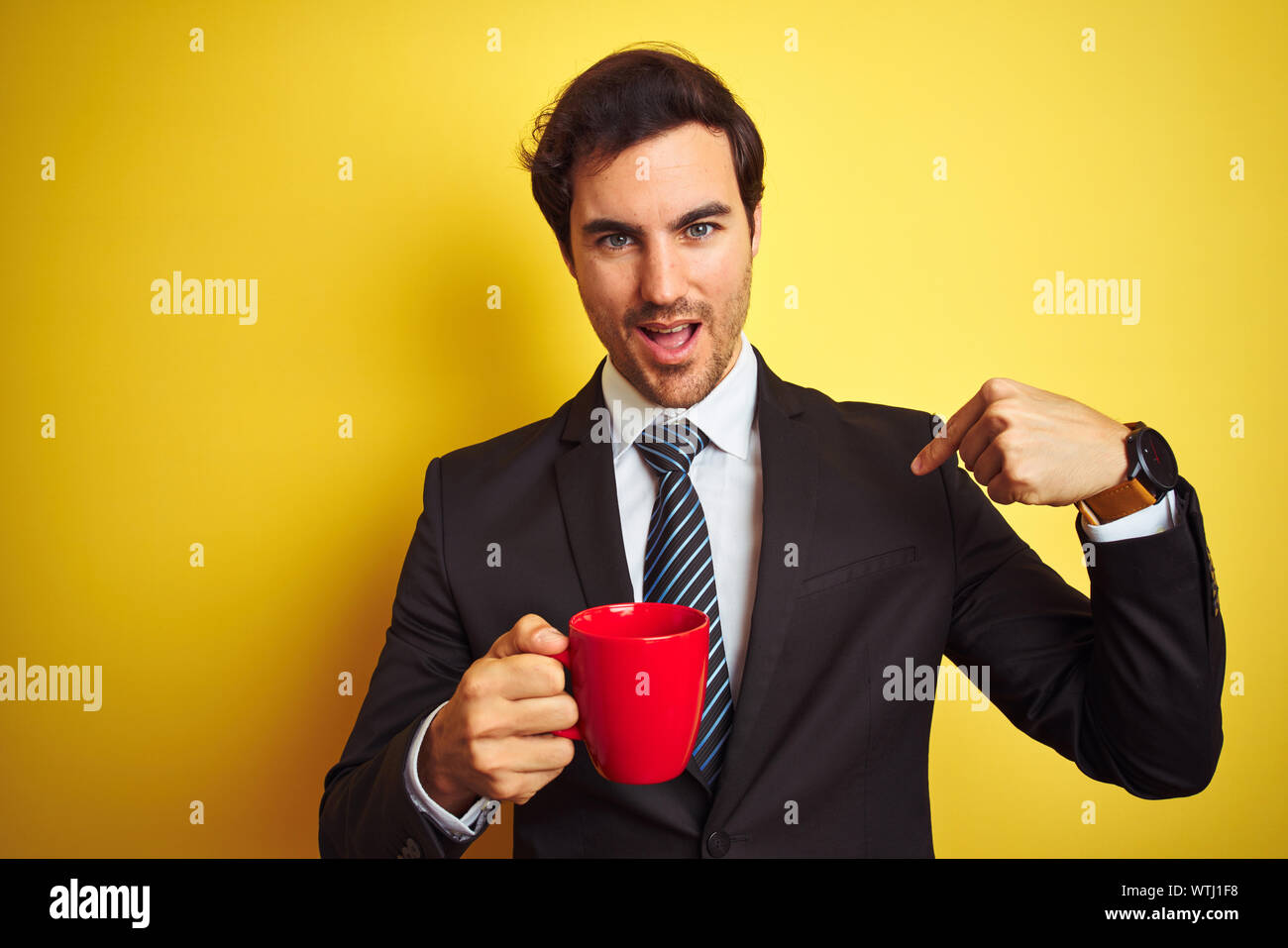 Young handsome businessman drinking red cup of coffee over isolated ...