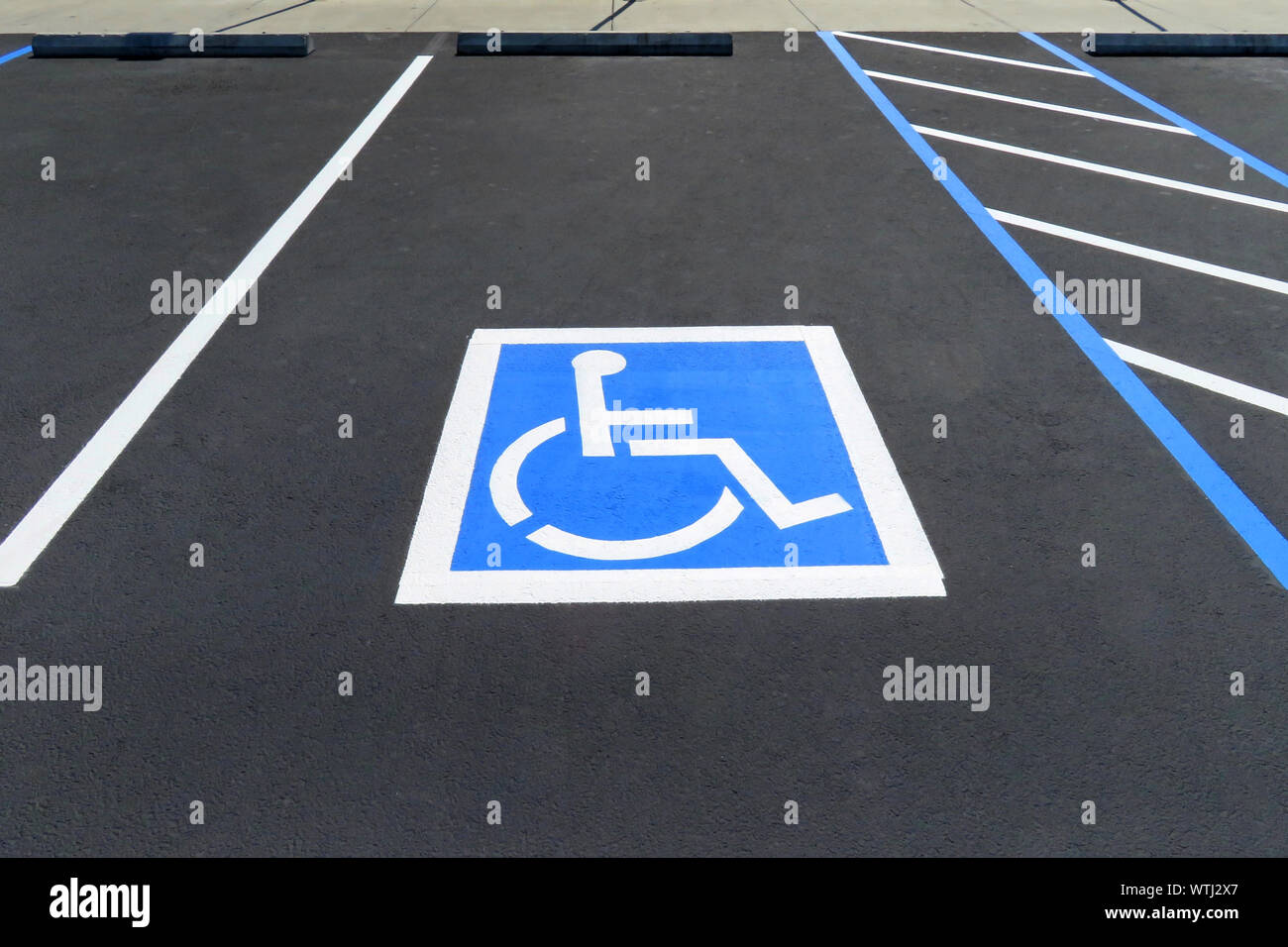 Freshly resurfaced and repainted handicap parking space in a parking