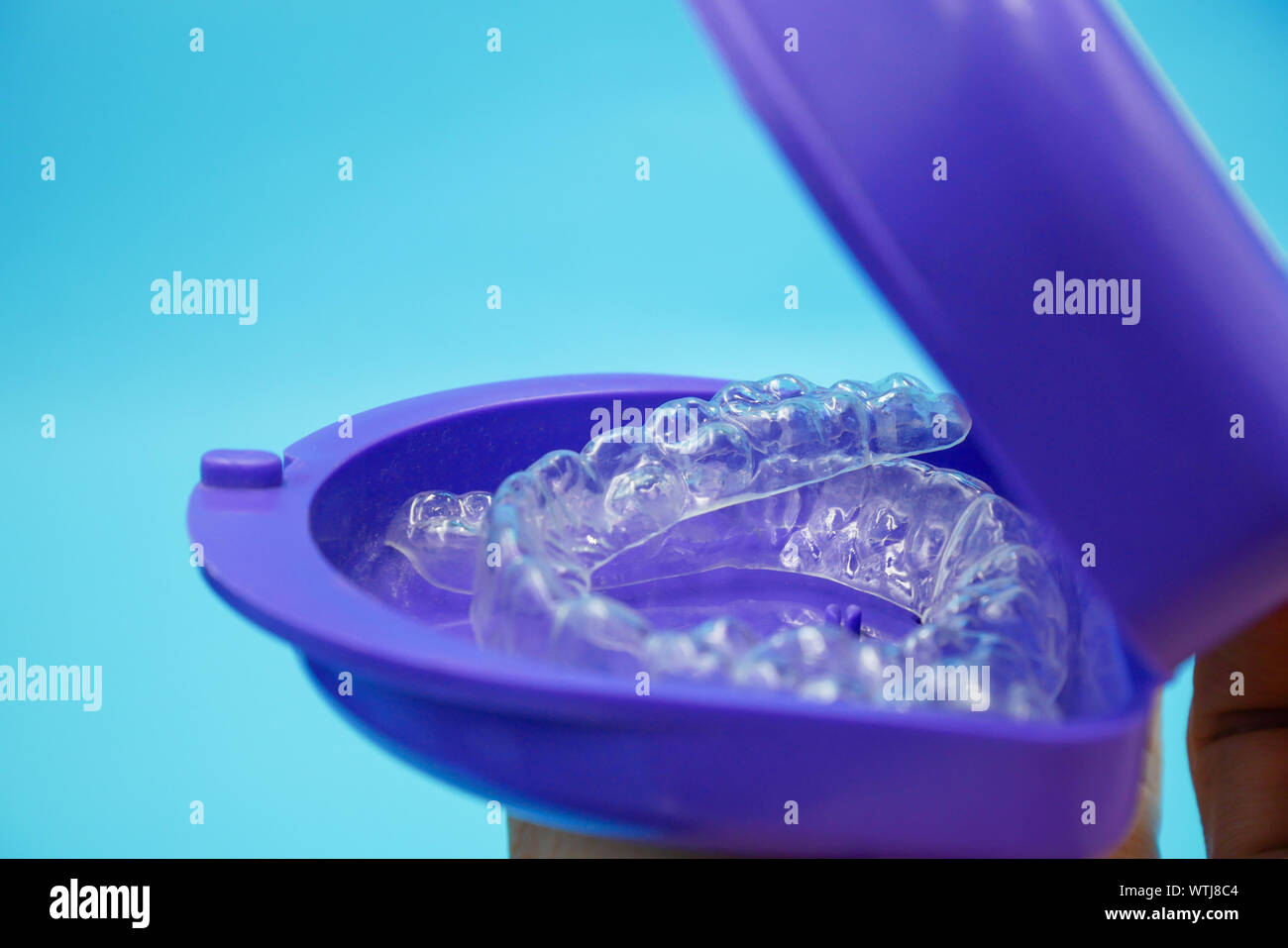 clear plastic retainer teeth in the box set isolated on blue sky ...