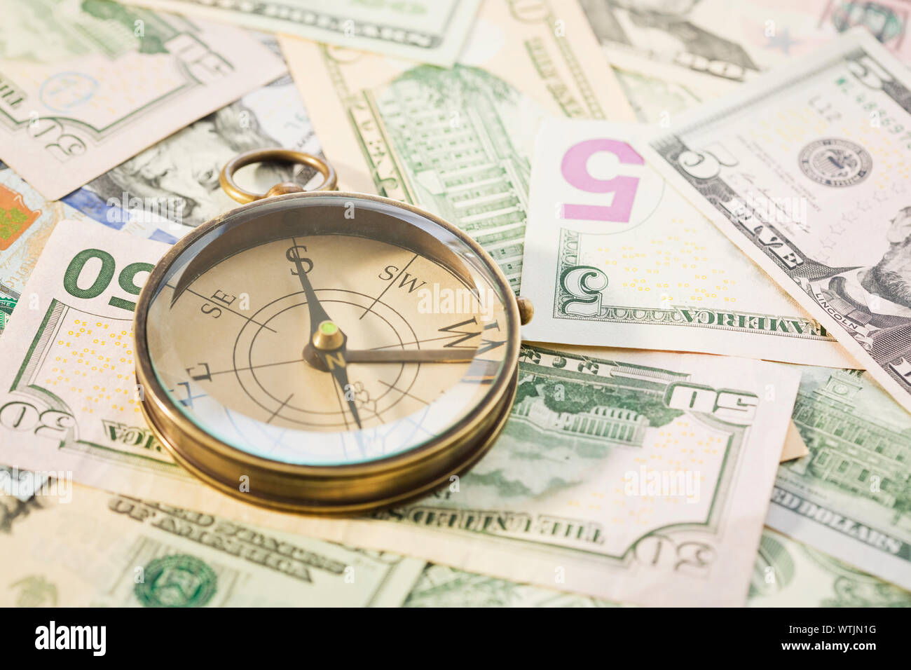 Close up of US paper currency and compass Stock Photo
