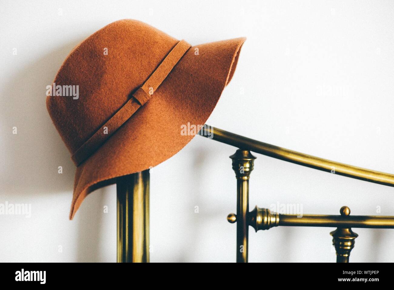 Hat On Stand Against White Wall Stock Photo
