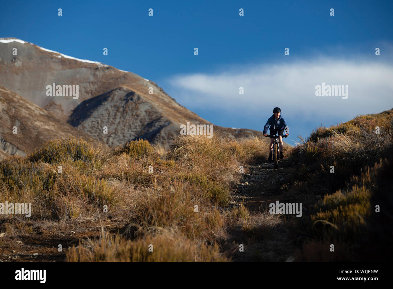 girl mountain biking near Porters skifield, New Zealand Stock Photo