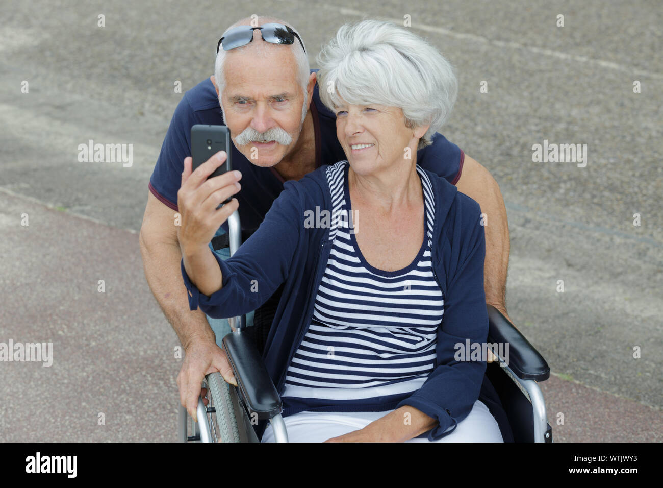 elderly couple taking selfie woman in wheelchair Stock Photo - Alamy