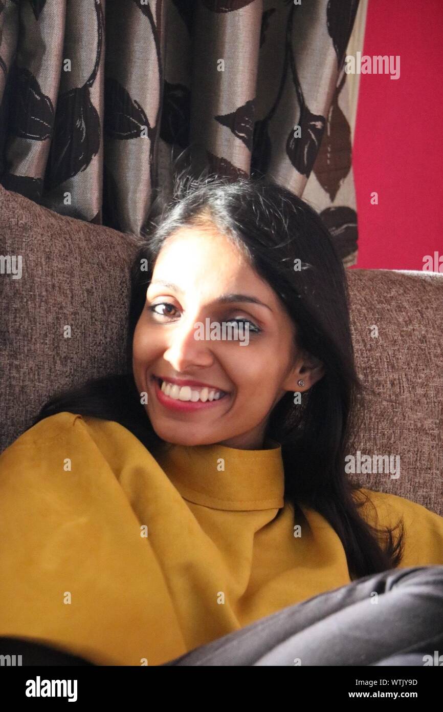 Indian woman sitting on couch hi-res stock photography and images - Alamy