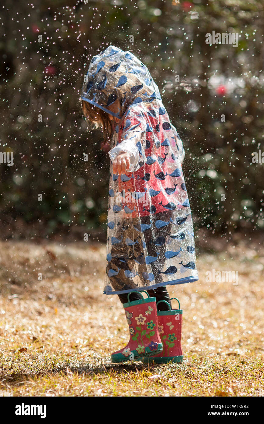 little girl in raincoat and boots walking in rain Stock Photo Alamy