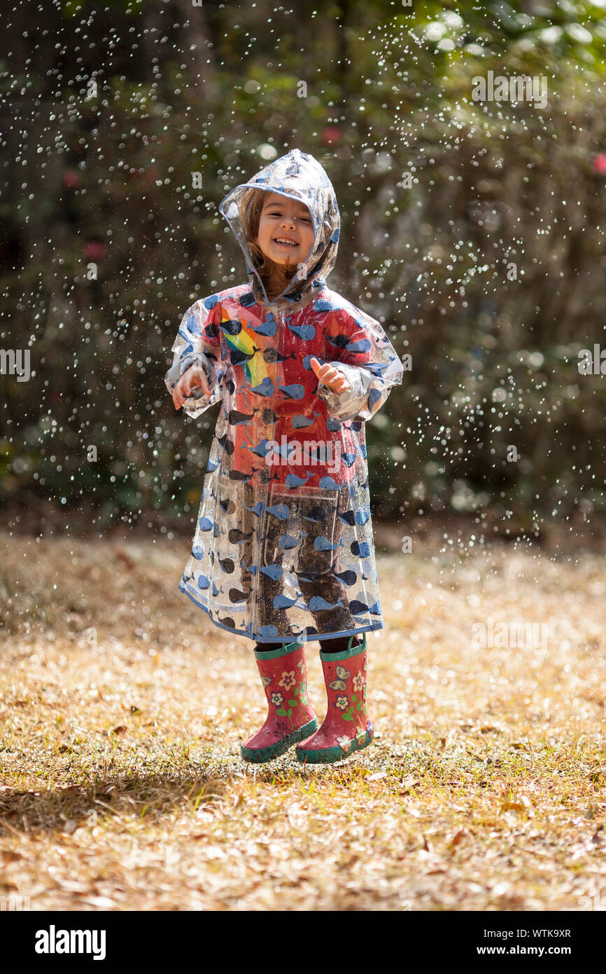 little girl in raincoat jumping in the rain Stock Photo Alamy