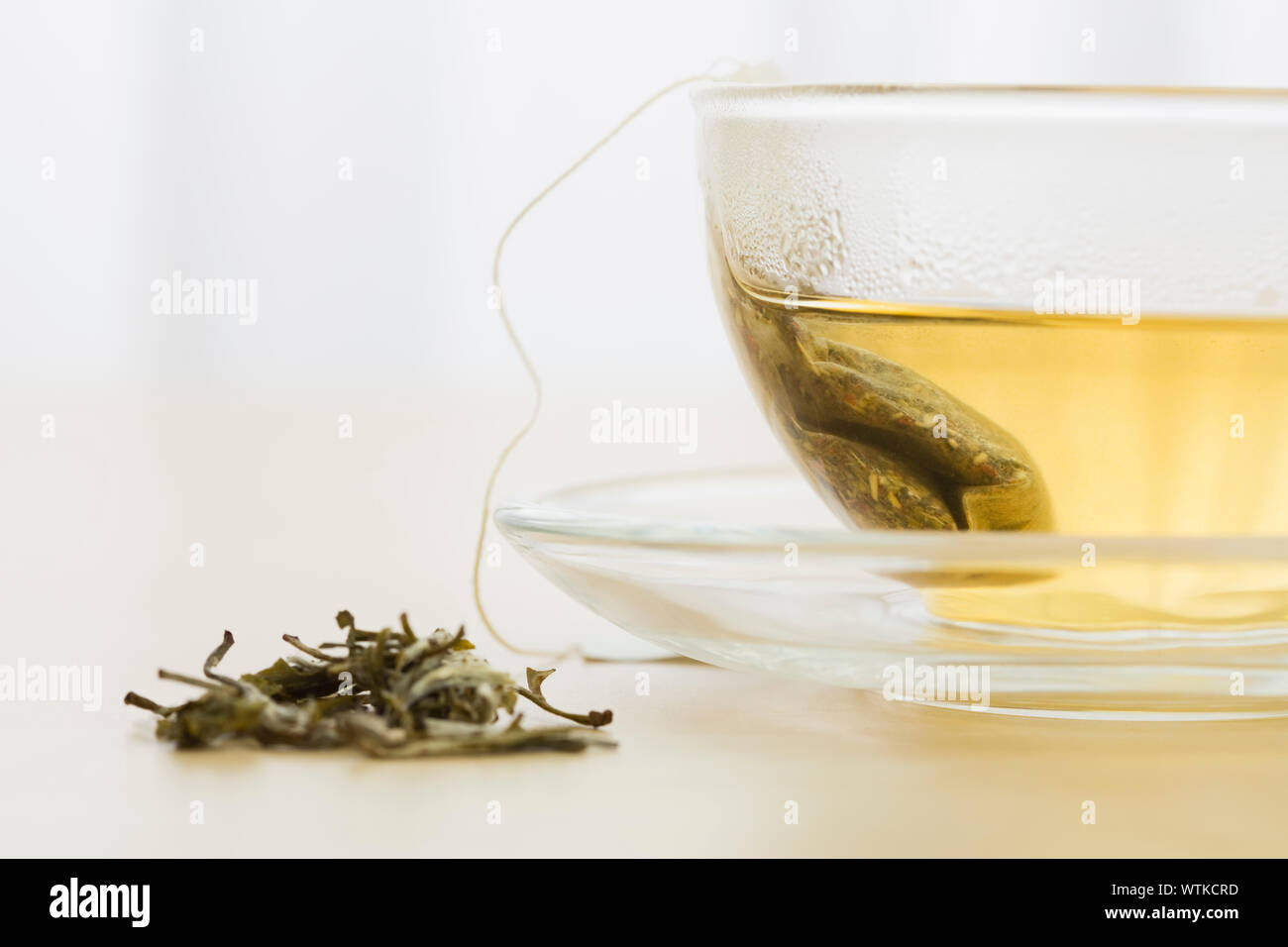 Green tea bag in cup and green tea leaves Stock Photo