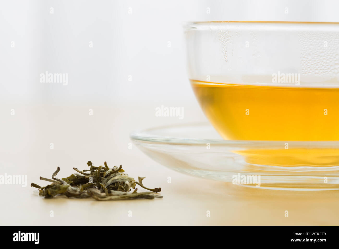 Cup of green tea and green tea leaves Stock Photo