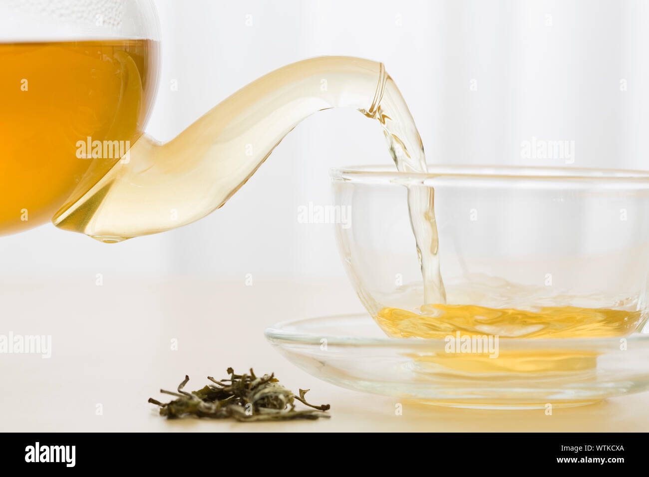 Green tea being poured into cup Stock Photo