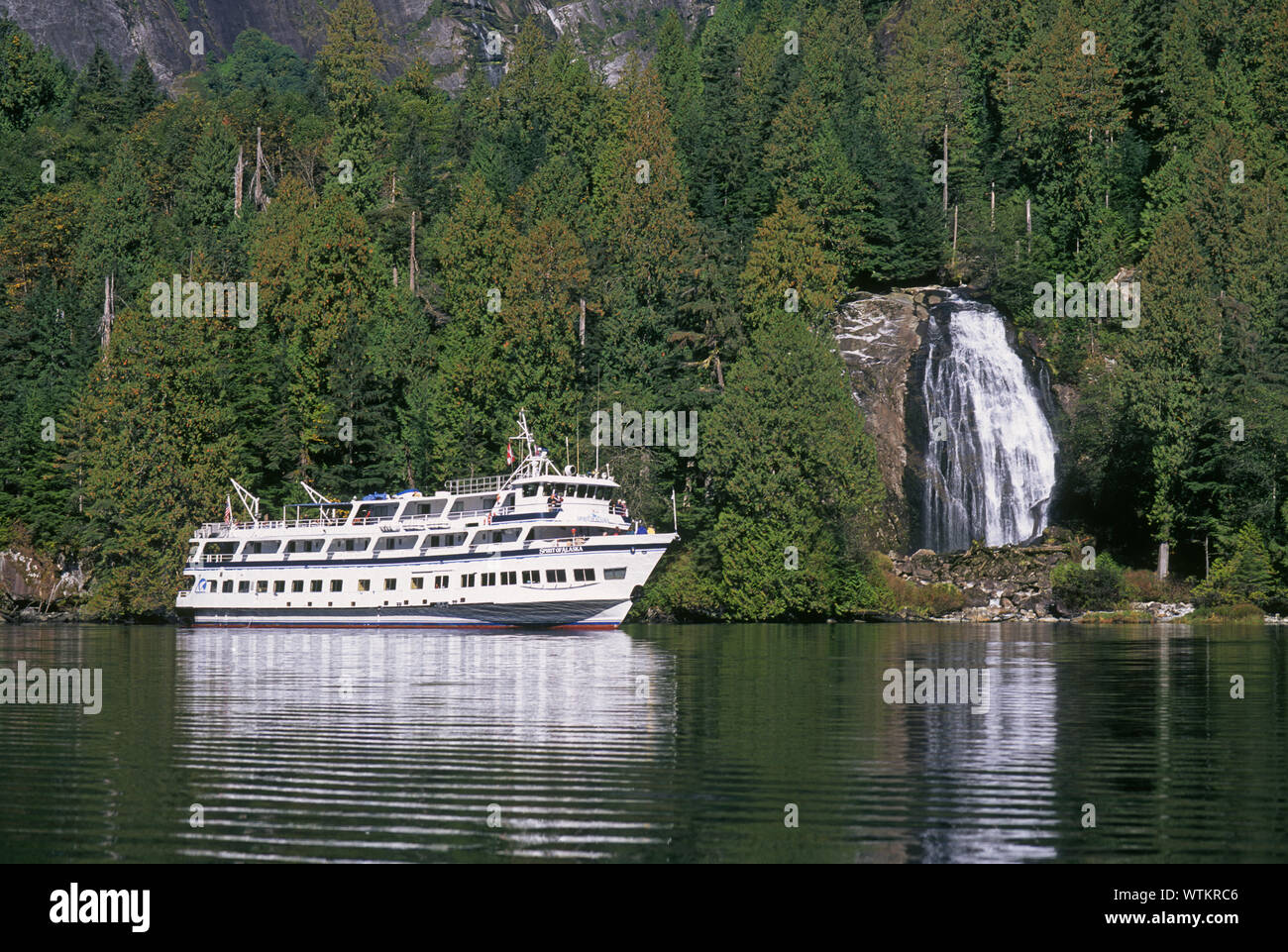 A small cruise ship gives passengers a close look at Chatterbox Falls in Princess Louisa Inlet, Inside Passage in western British Columbia, Canada. Stock Photo