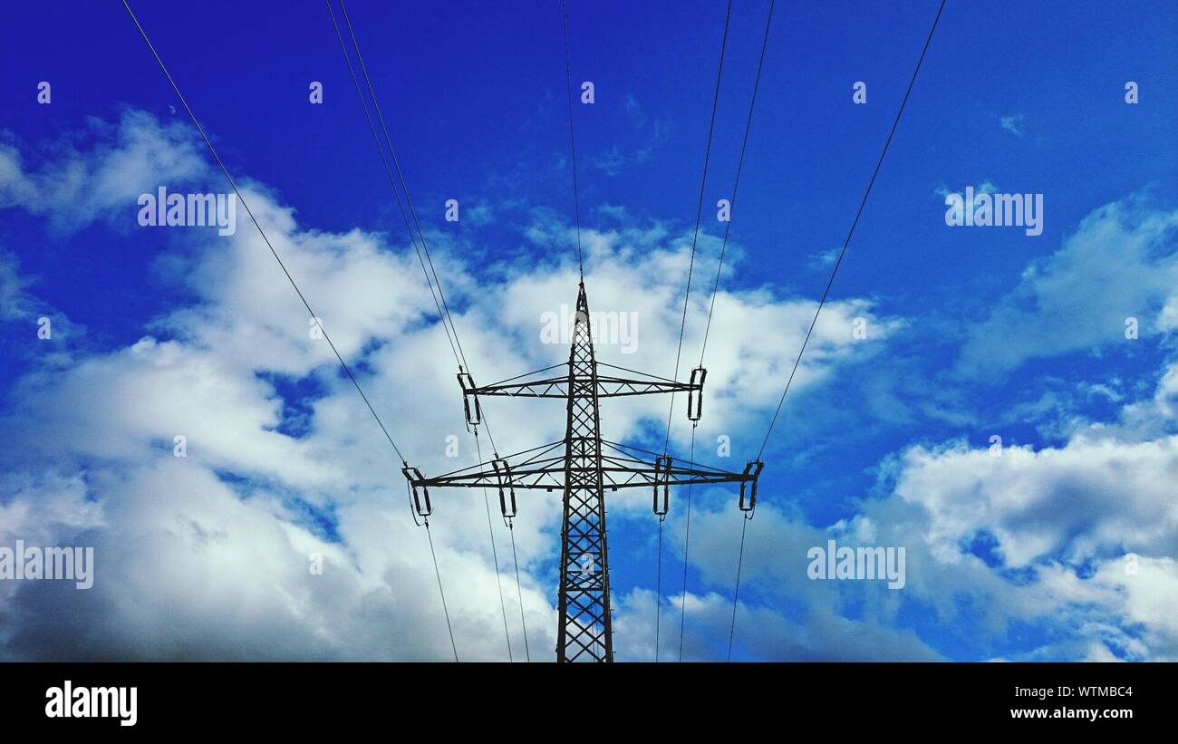 Low Angle View Of Power Tower Against Blue Sky Stock Photo