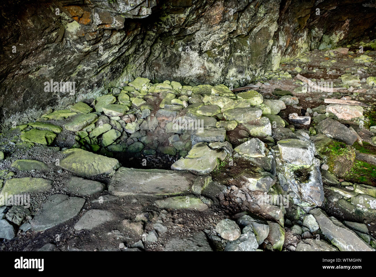 The remains of the illicit distillery still in the Whisky Cave, on the Treshnish Peninsula coast walk, Isle of Mull, Scotland, UK Stock Photo