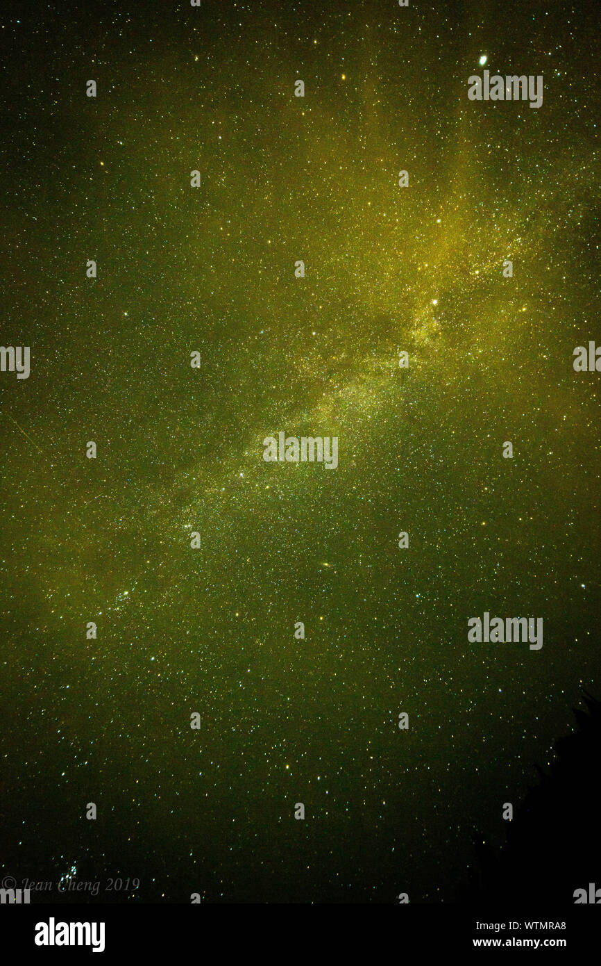 STEVE (Strong Thermal Emissions Velocity Enhancement) appears across the sky crossing the Milky Way galaxy. Stock Photo