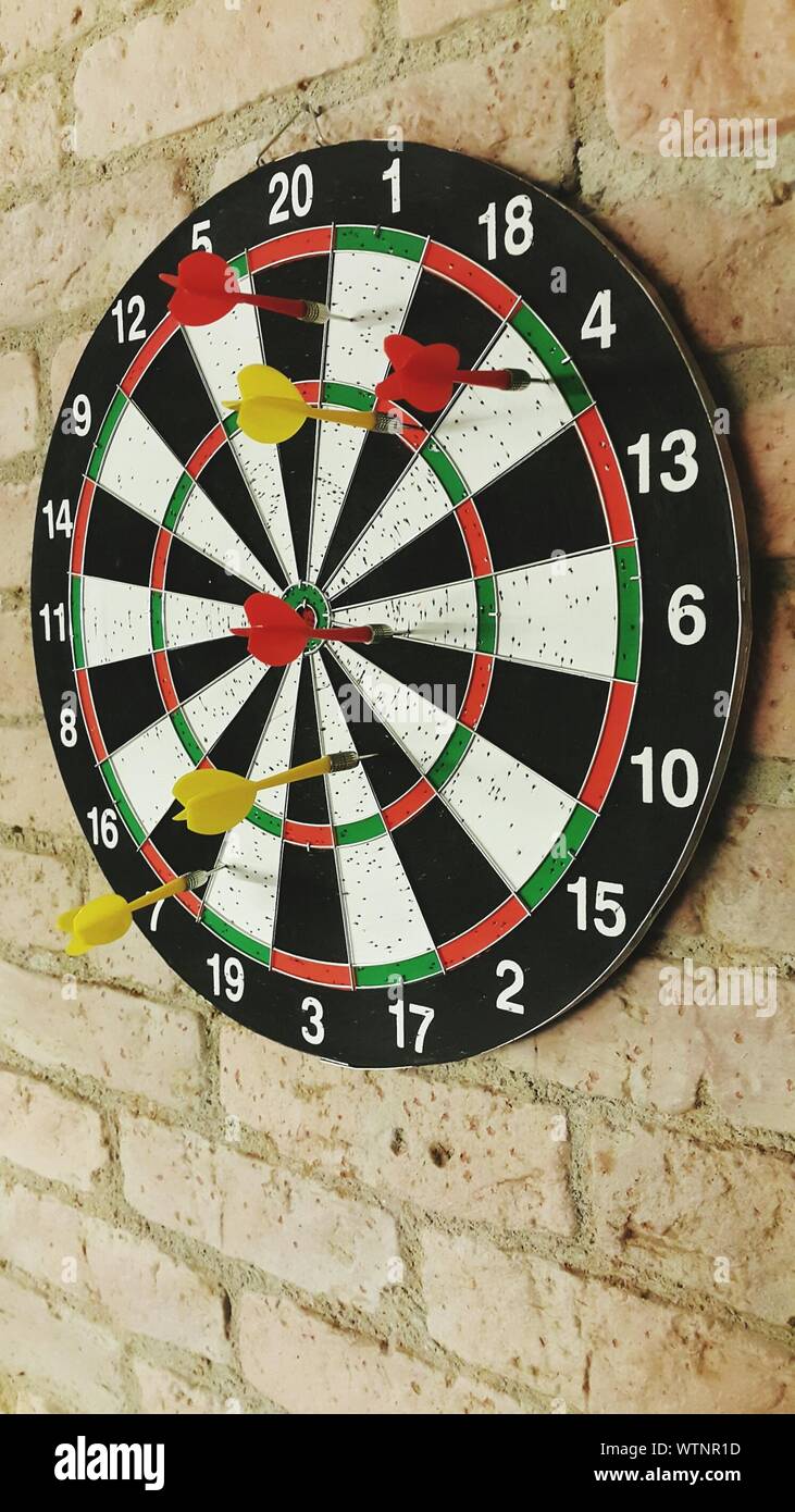 Darts Stuck On Dartboard Mounted On Brick Wall Stock Photo Alamy