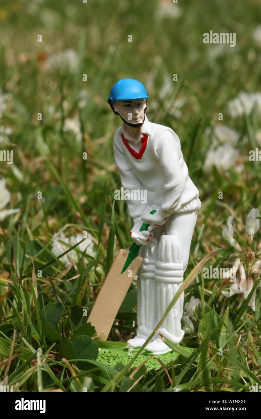 Cricketer Figurine On Grass In Yard Stock Photo