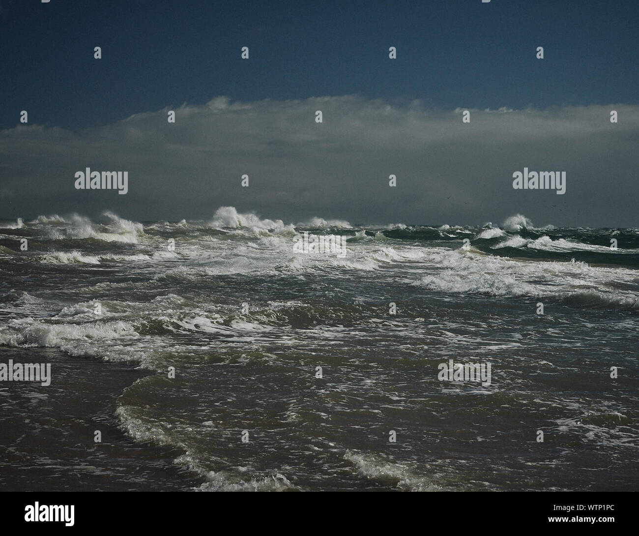 Scenic View Of Stormy Sea Against Cloudy Sky Stock Photo