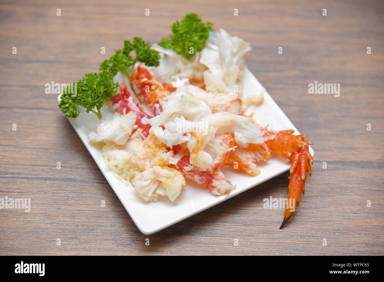 crab meat on white plate with spices for cooked seafood / red crab legs