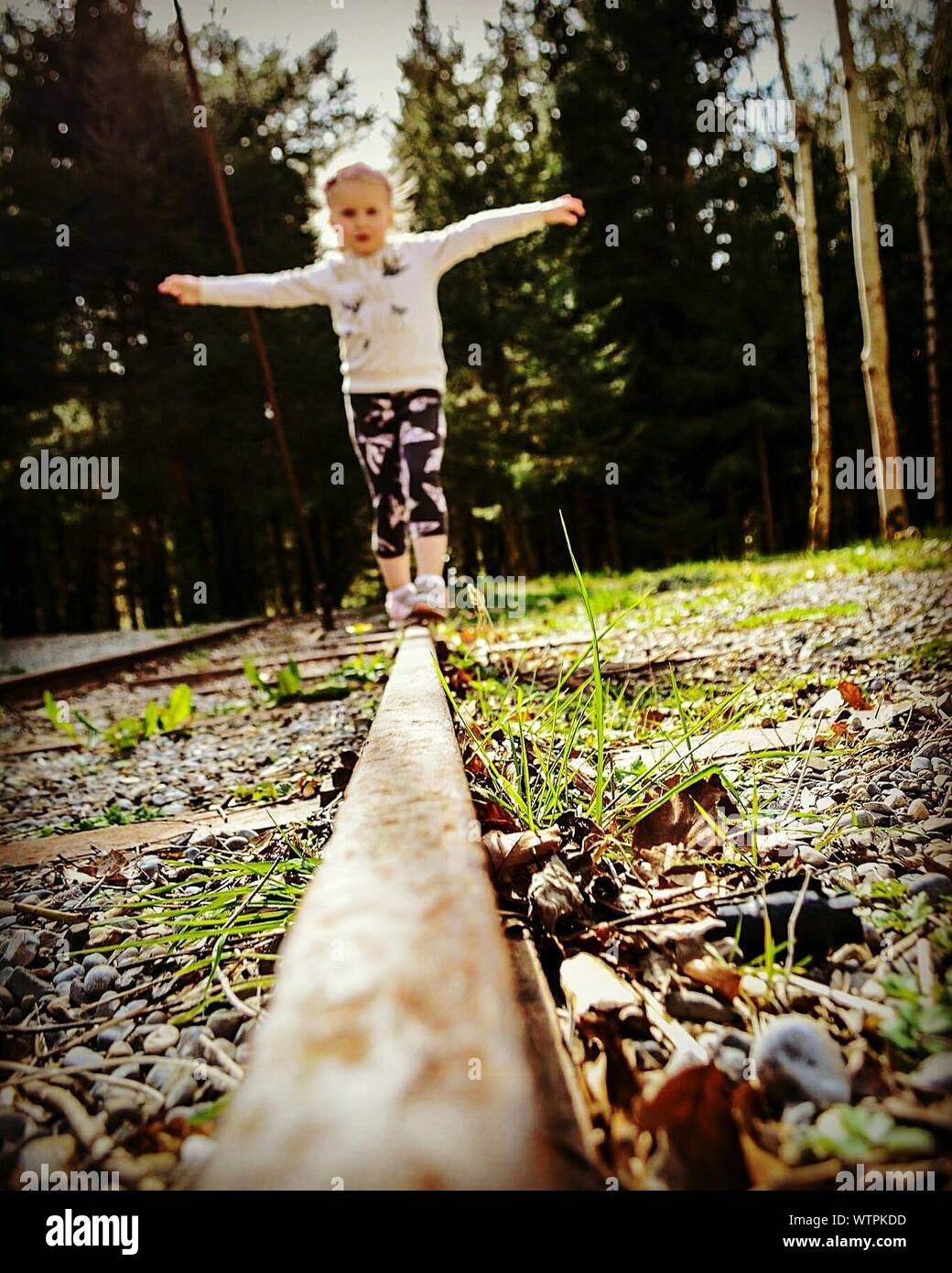 Full Length Of Girl Balancing On Railroad Track Stock Photo - Alamy