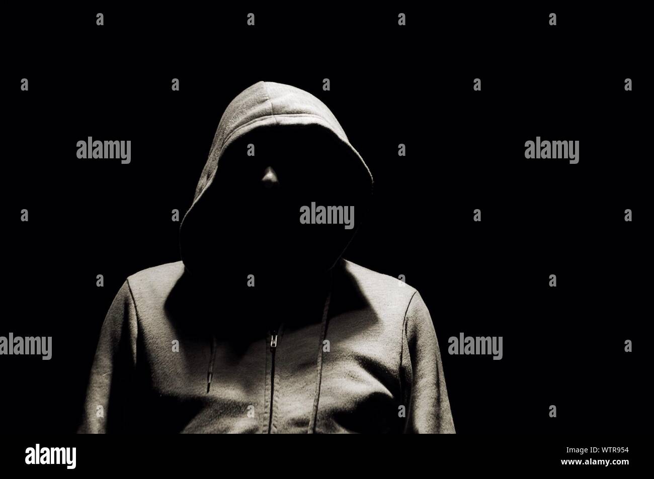 Man In Hooded Jacket Over Black Background Stock Photo