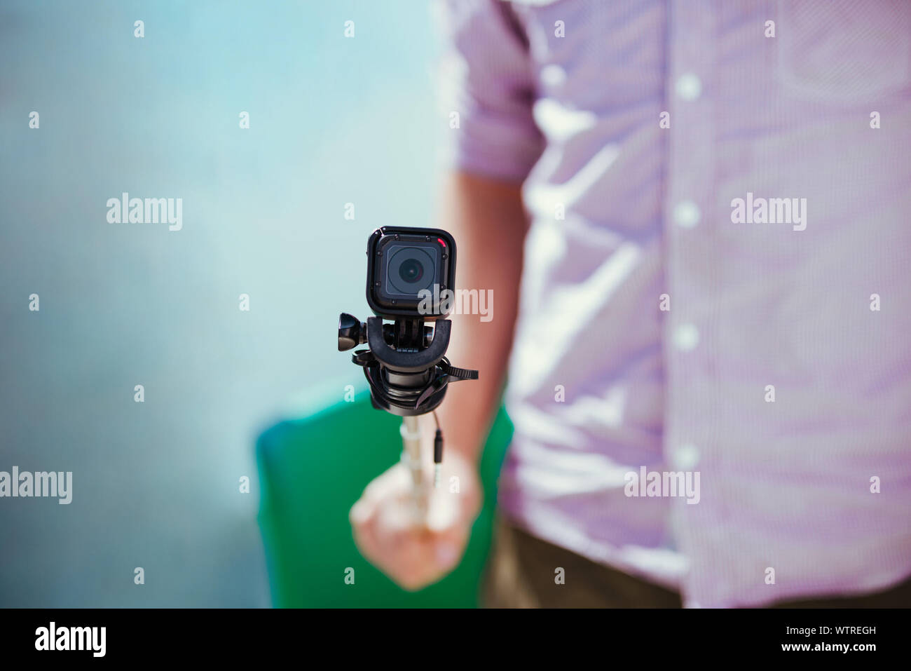 Midsection Of Man Holding Wearable Camera Stock Photo