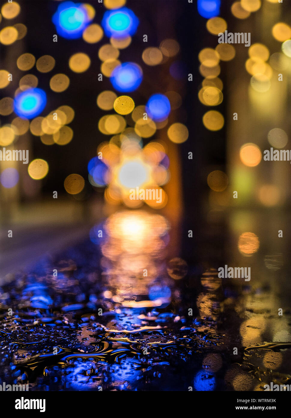 Surface Level Image Of Wet Street Against Illuminated Christmas Lights At  Night Stock Photo - Alamy