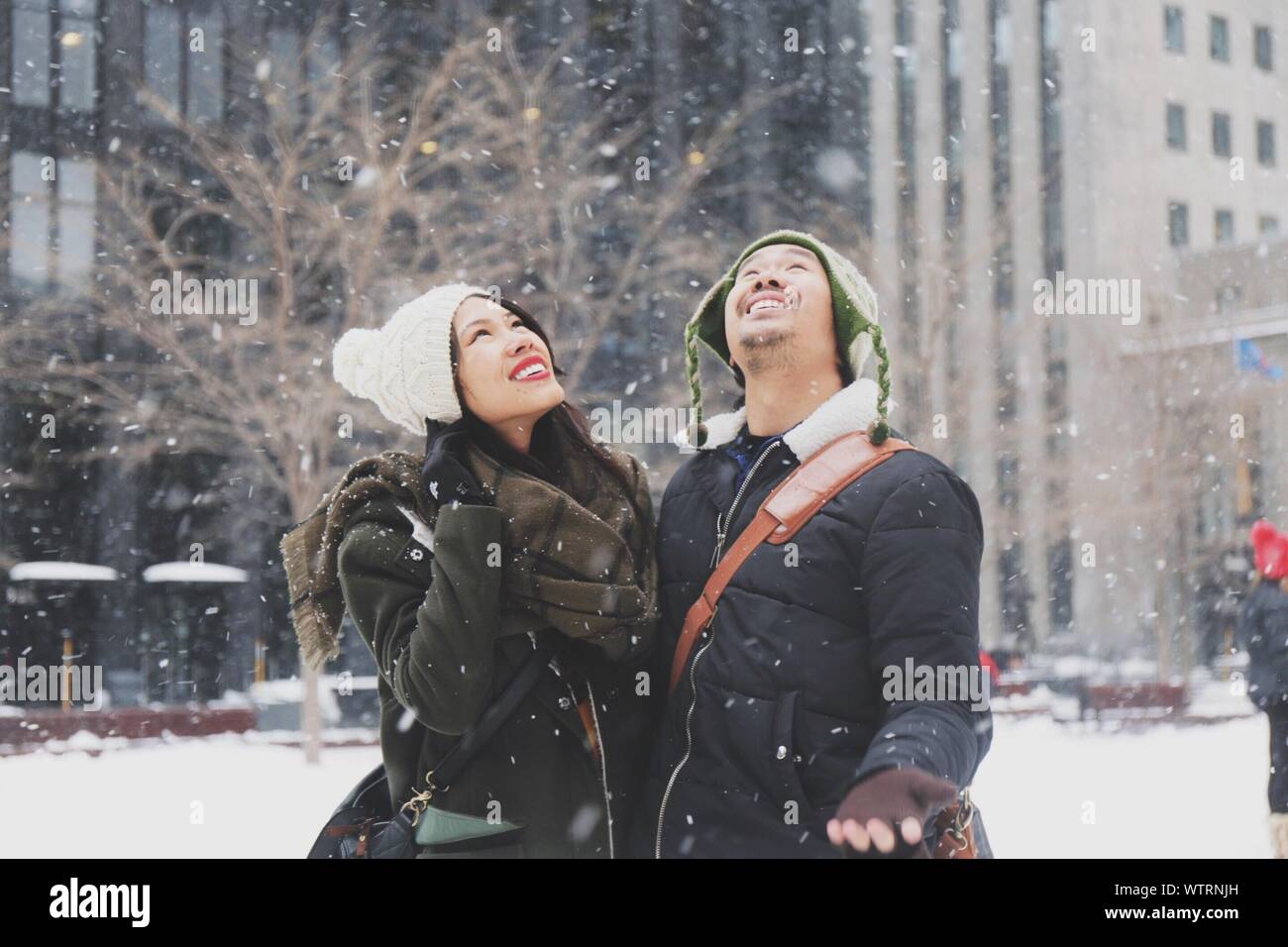 Couple enjoying snowfall hi-res stock photography and images - Alamy