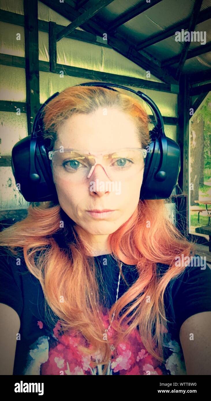 Portrait Of Redhead Woman Wearing Ear Protectors Stock Photo