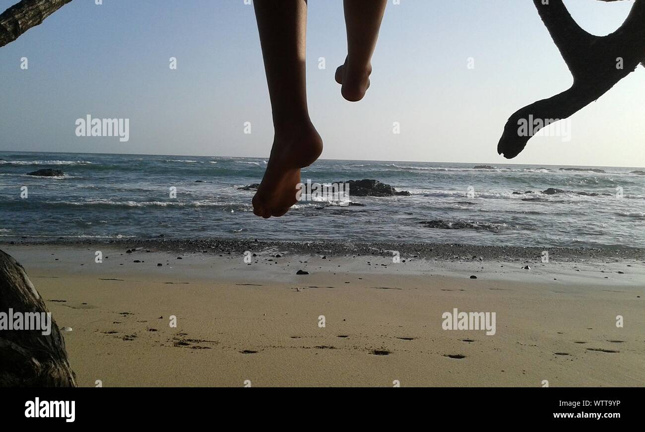Legs Dangling Over Beach Stock Photo