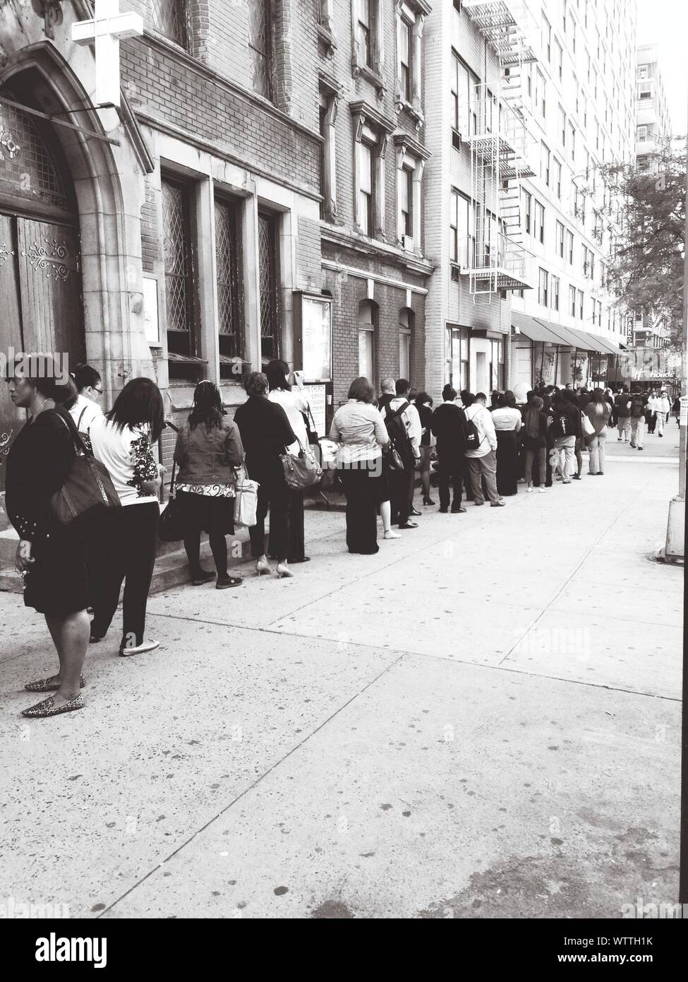 Black And White Image Of People Standing In Line Stock Photo