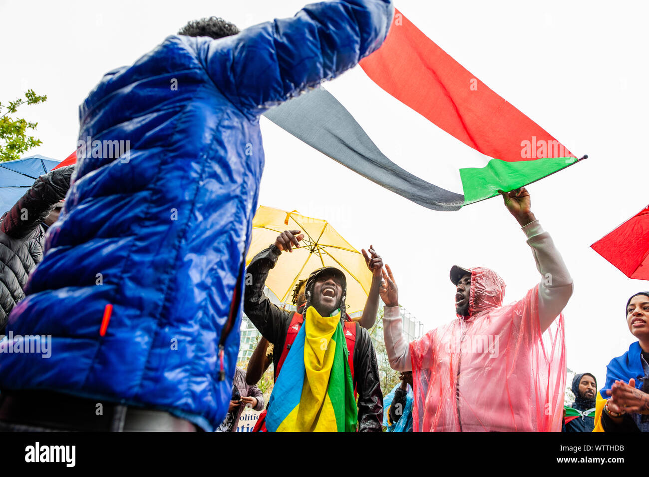 A group of Sudanese people dance below a Sudanese flag during the march.From September 6th to 11th, an international Sudanese march took place starting in London and ending in The Hague after stopping in France and Belgium. On September 11th, the march arrived in front of the International Criminal Court building, situated in The Hague. The march was held in solidarity with the Sudanese revolution and calls for the prosecution of military criminals in Sudan. The march was organized by the Sudanese Initiative Europe. Stock Photo