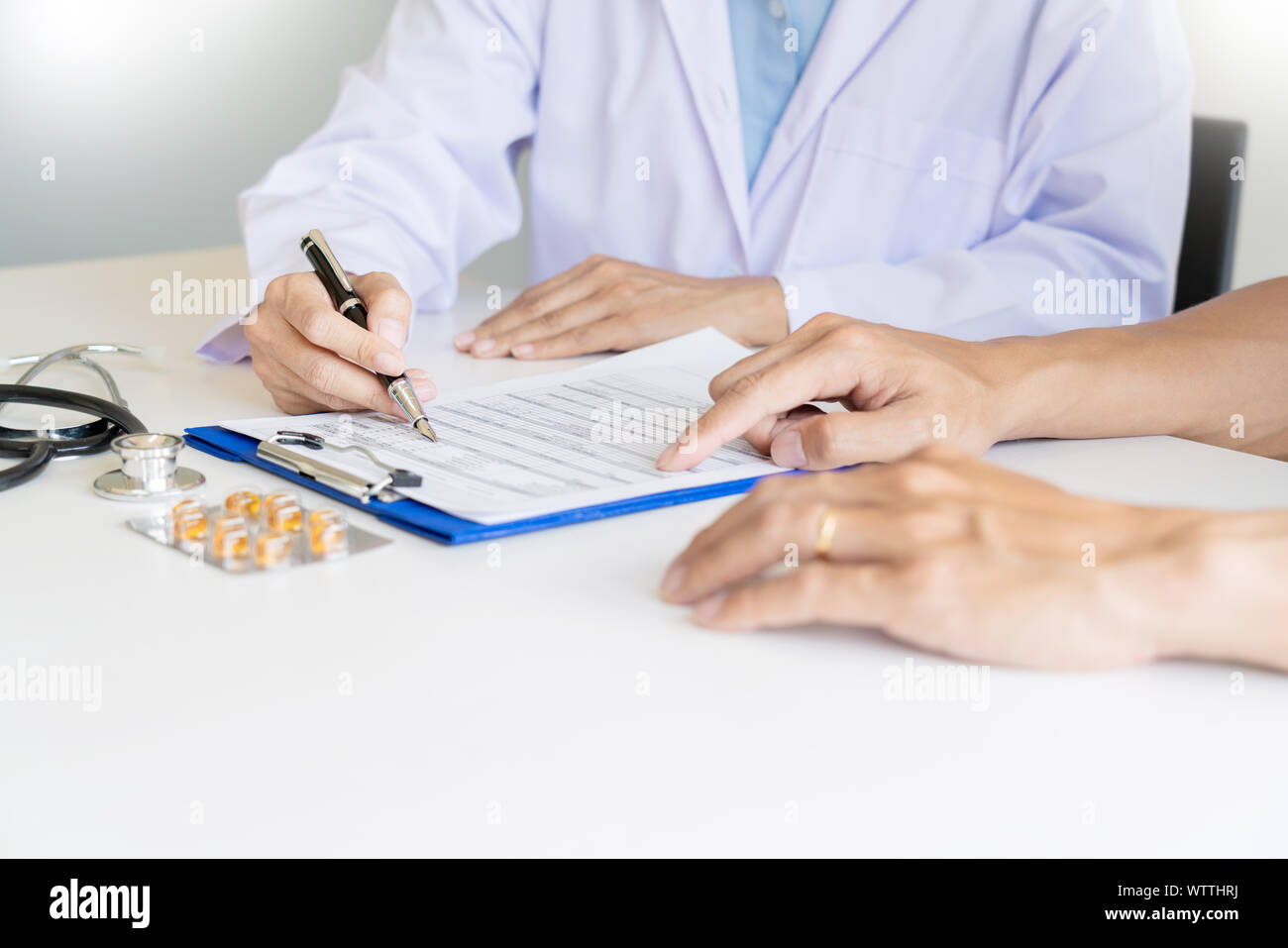 Doctor explaining for patient and showing medical records informations ...