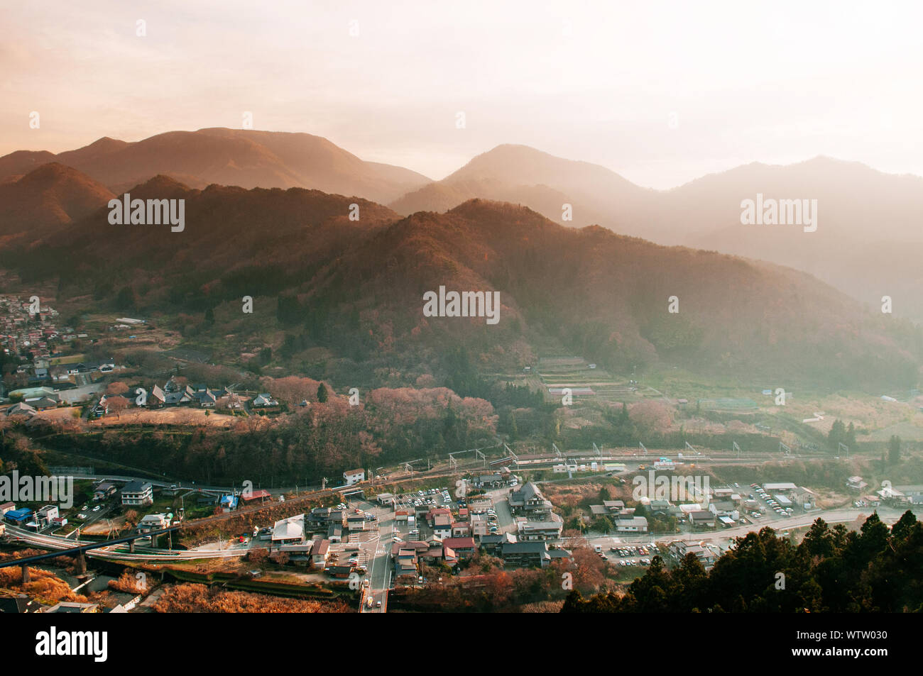 Yamadera town in mountain valley under evening sunlight through foggy ...
