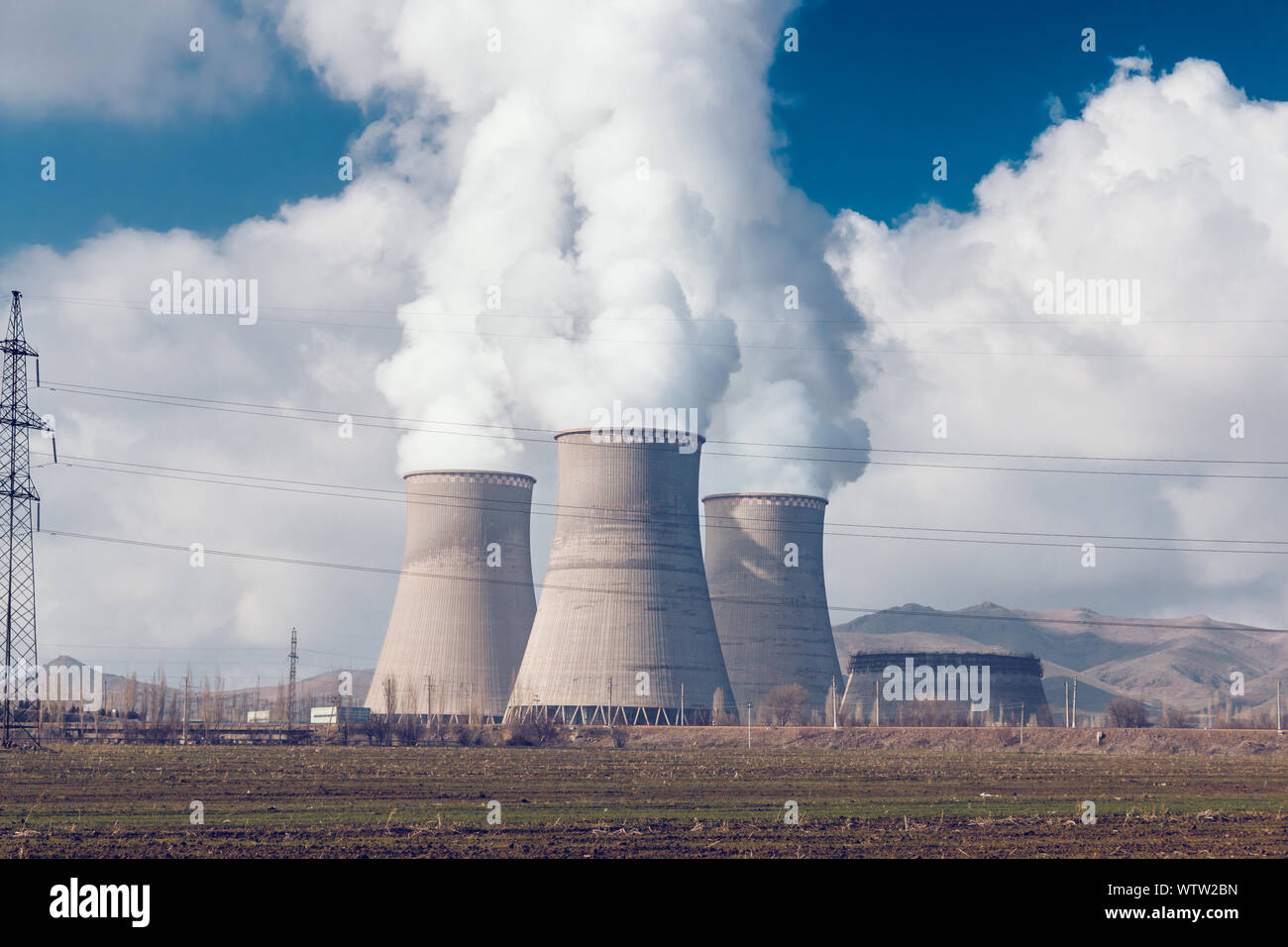 Factory pipes with thick white smoke from heat energy nuclear plant polluting environment Stock Photo