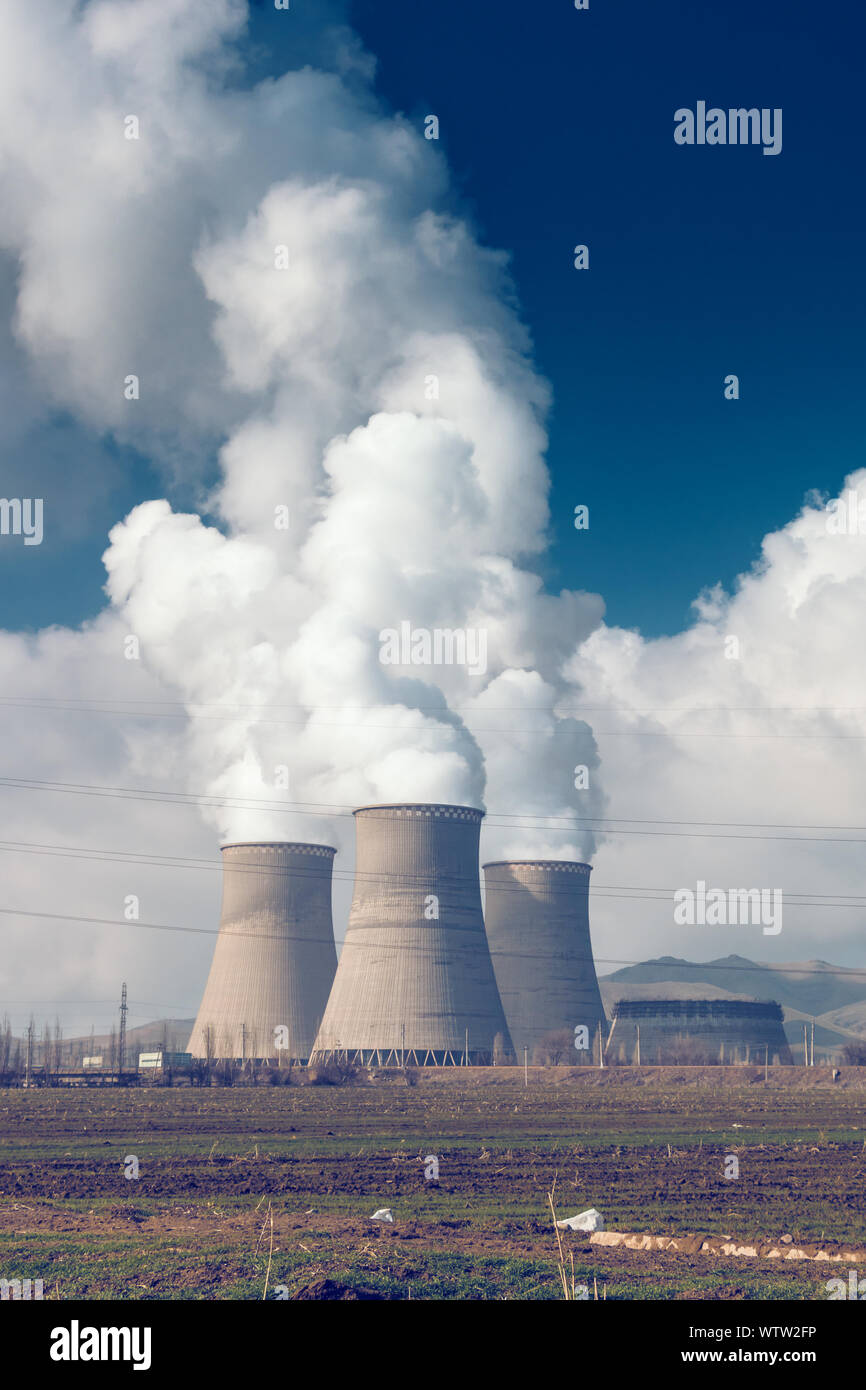 Factory pipes with thick white smoke from heat energy nuclear plant polluting environment Stock Photo