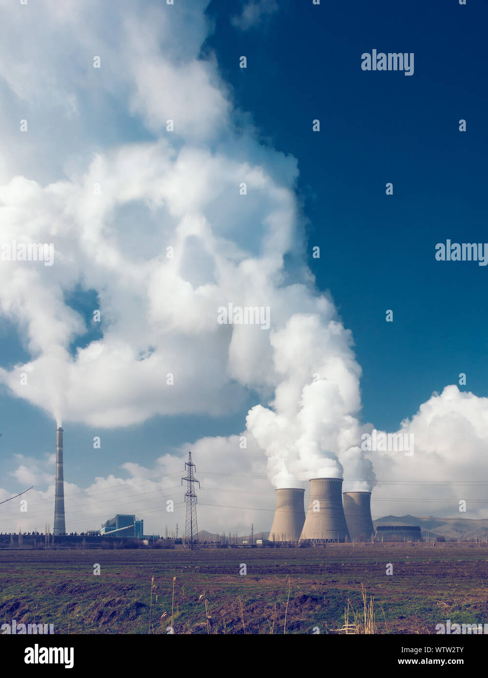 Factory pipes with thick white smoke from heat energy nuclear plant, environment pollution concept with smoke skull Stock Photo