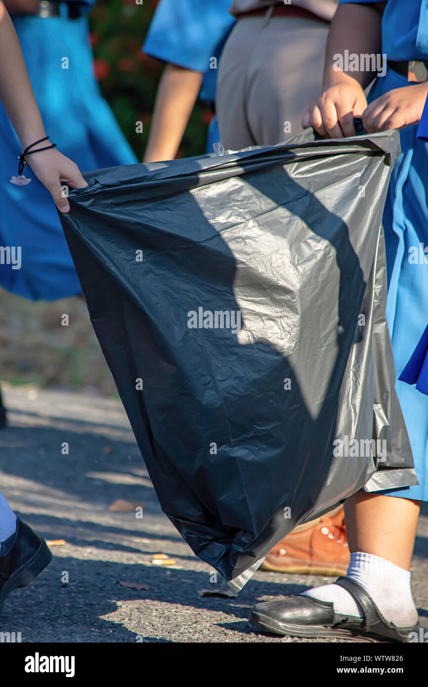 Hand Asean girl holding Black garbage bags. Stock Photo