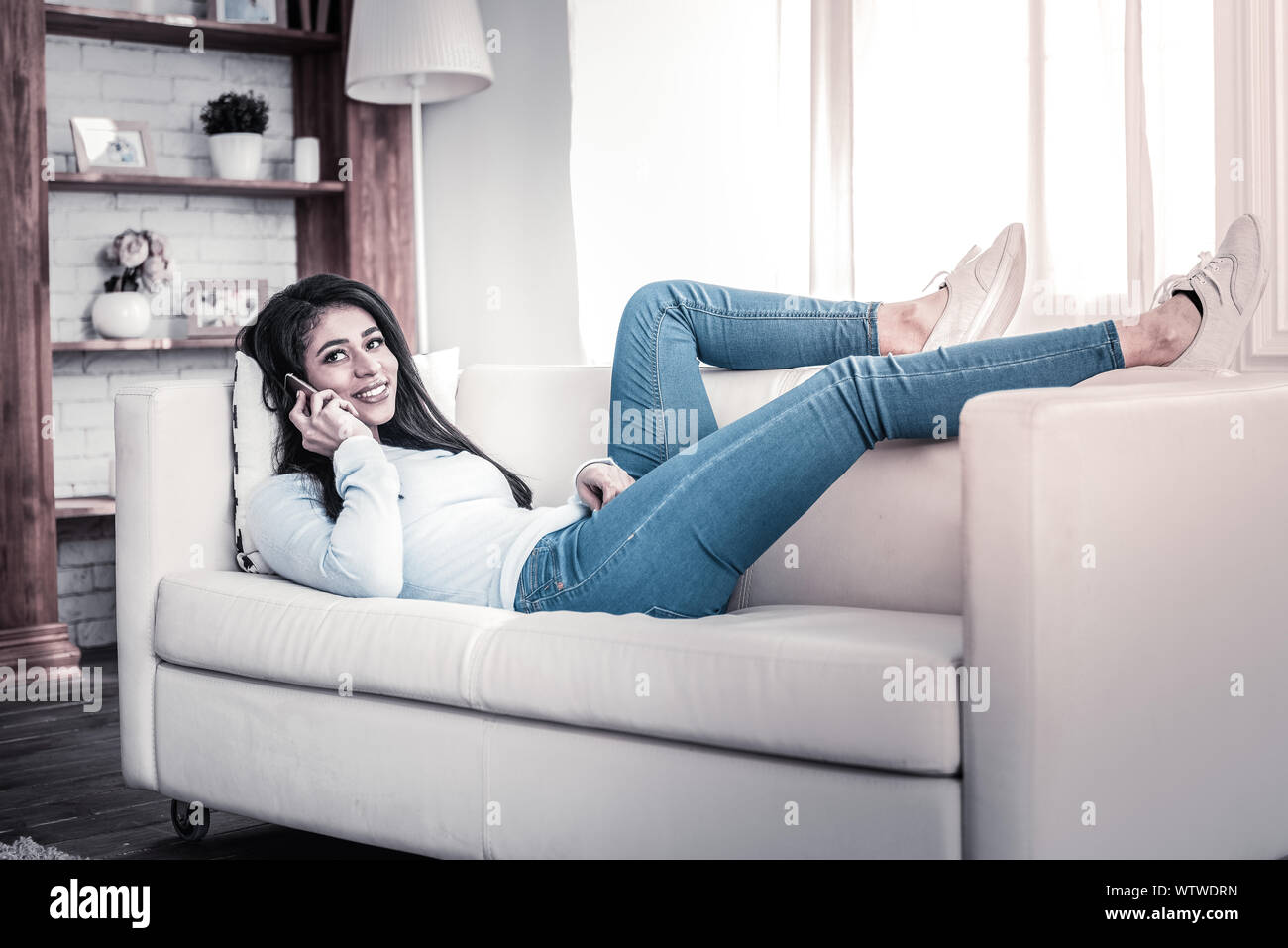Beautiful long-haired girl having conversation on her phone Stock Photo