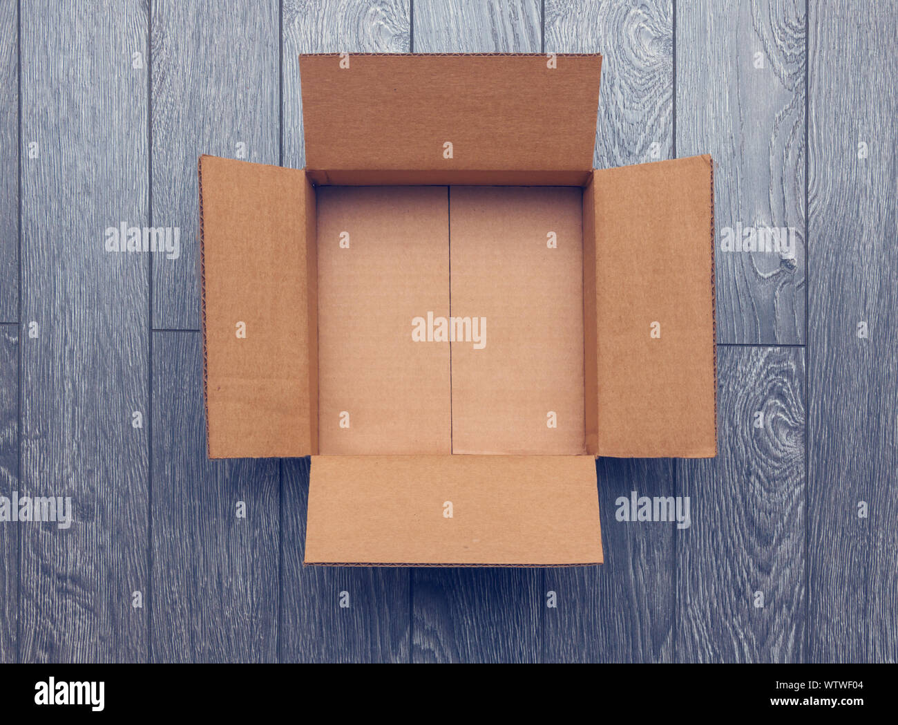 Flat lay of empty open cardboard box on wooden surface Stock Photo
