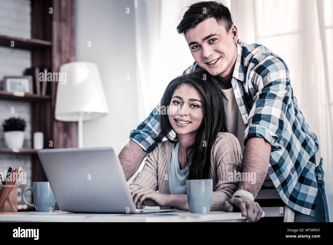 Mixed race young lady sitting on the chair with her boyfriend Stock Photo