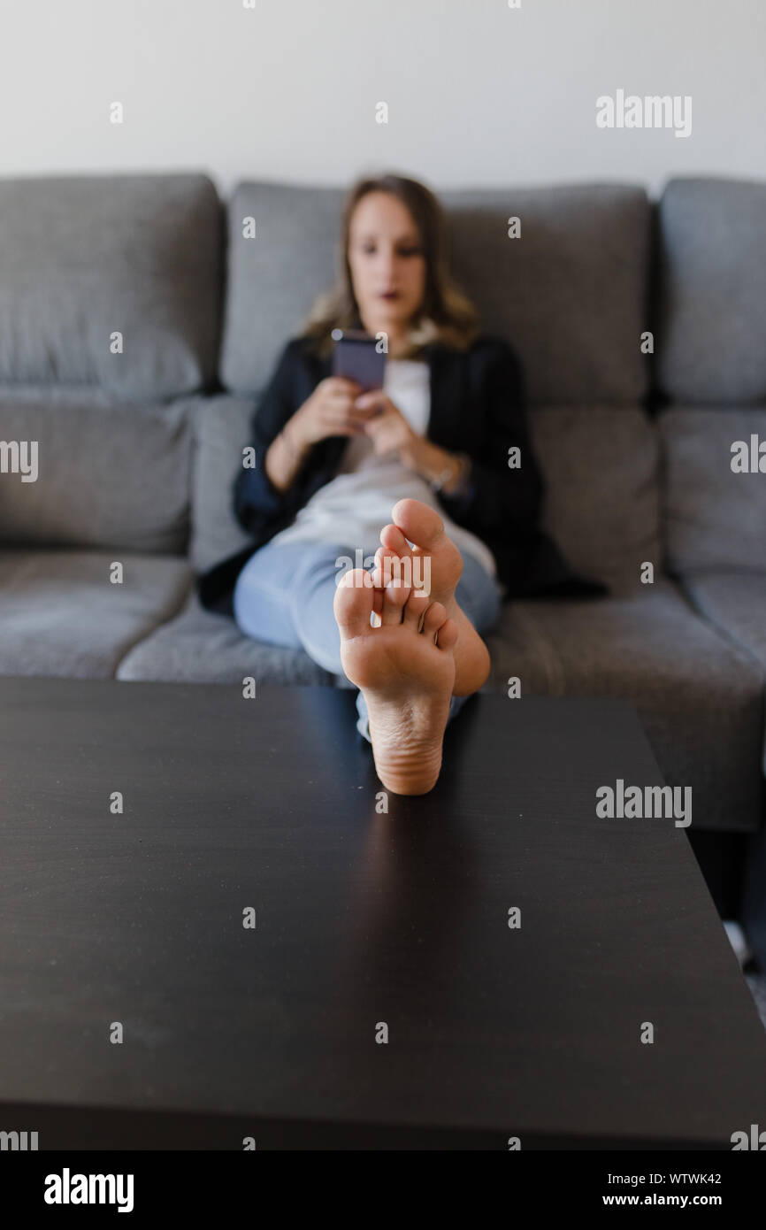 woman in a couch with mobile phone unfocus Stock Photo