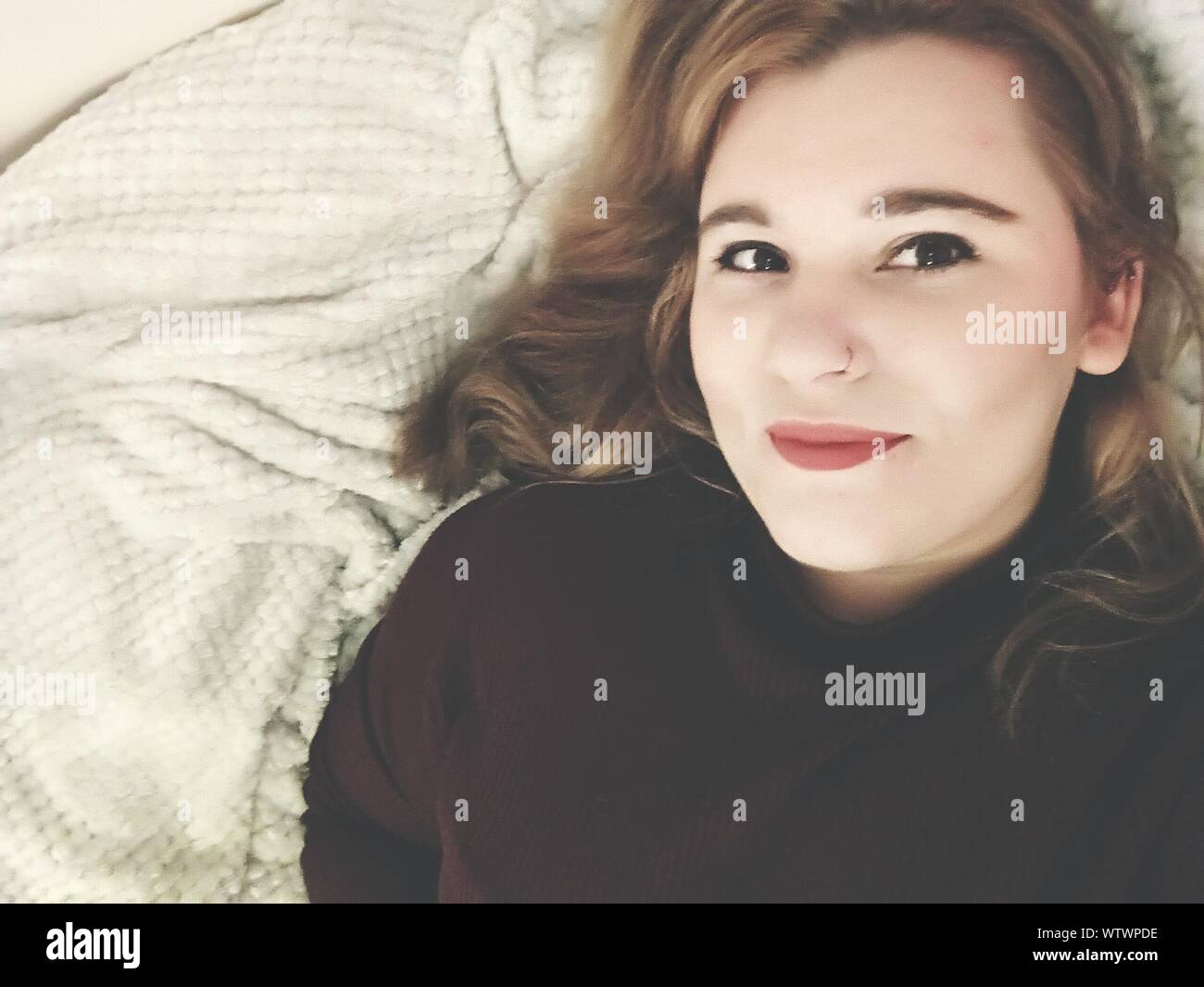 Close-up Portrait Of Beautiful Young Woman Lying On Bed Stock Photo - Alamy