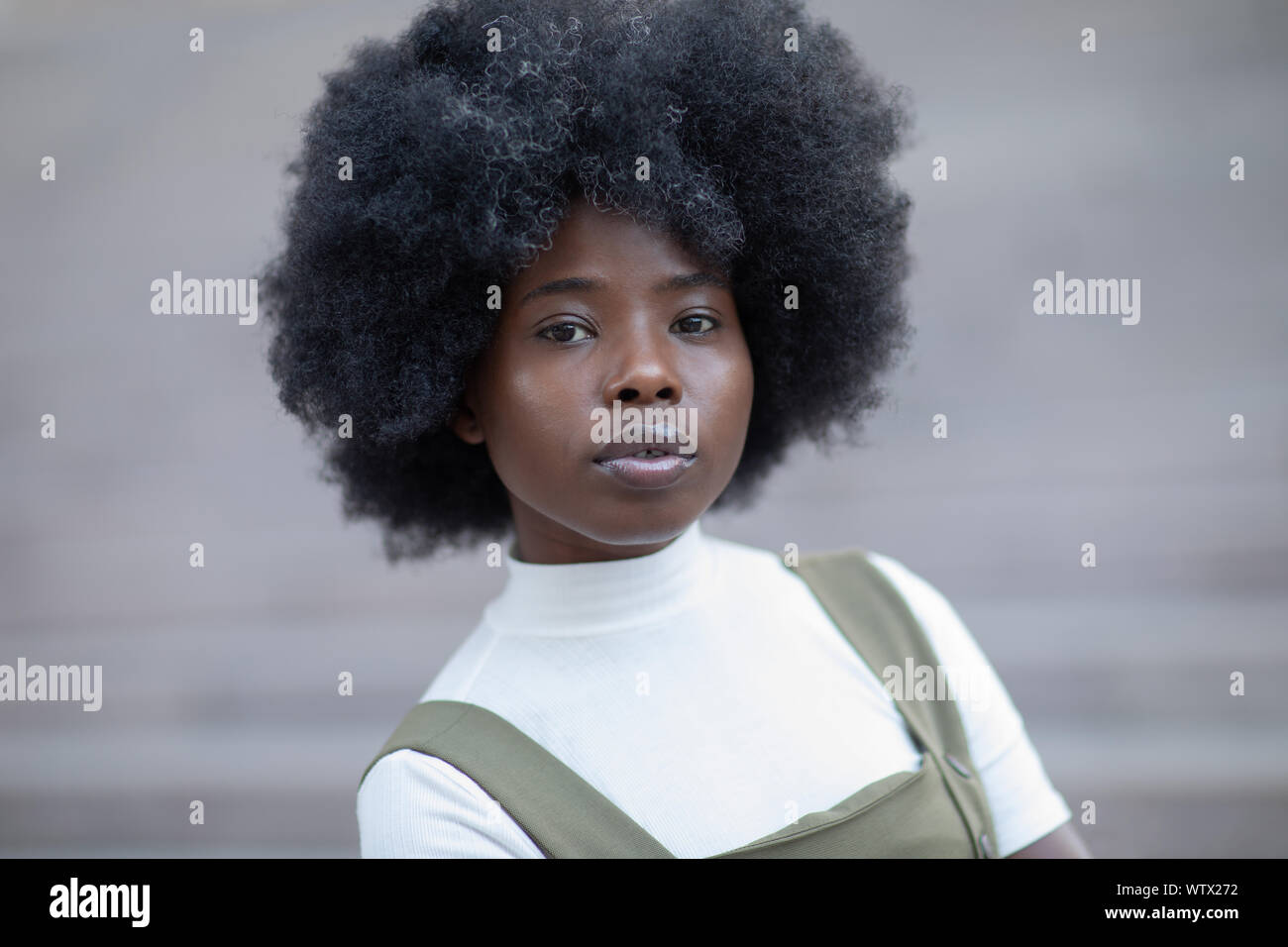 Inspired African American Woman Looking Afar Standing On Concrete