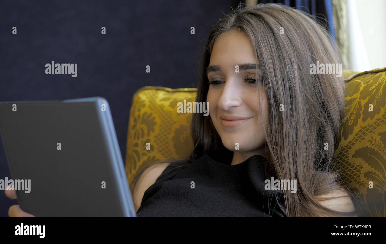 Beautiful girl lying on the couch in the hotel Stock Photo - Alamy