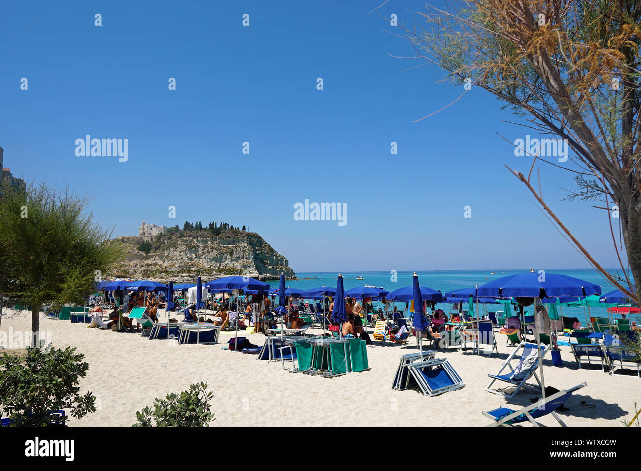 The public beach in Tropea, Calabria, Italy. View from the north, August 2019. There is the hill with the Church of Santa Maria dell'Isola at the back. Stock Photo