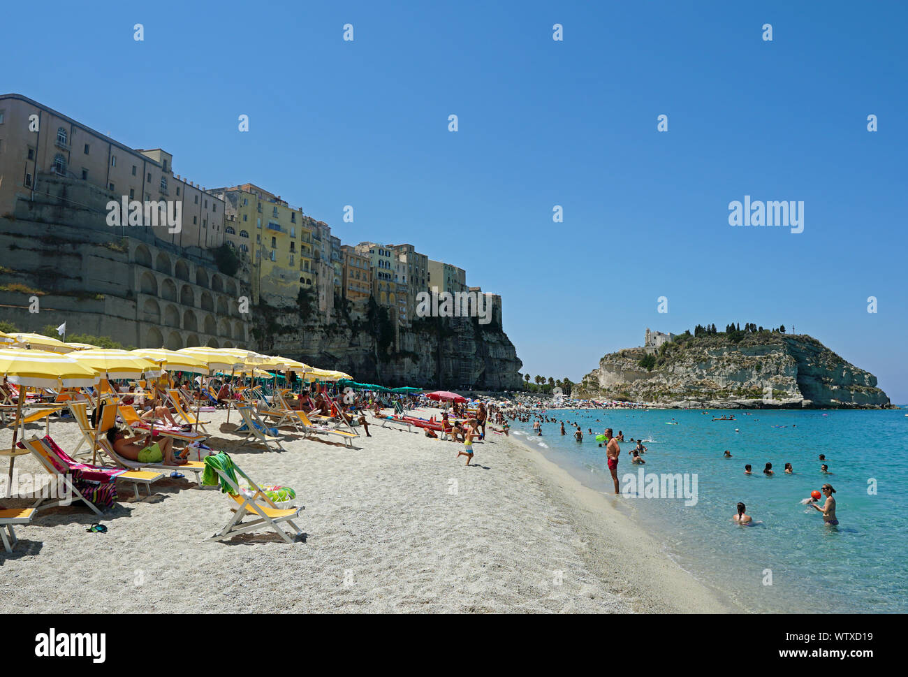 The public beach in Tropea, Calabria, Italy. View from the north, August 2019. There is the hill with the Church of Santa Maria dell'Isola at the back. Stock Photo