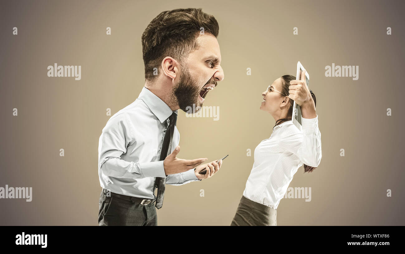 Angry businessman screaming at employee in the office. Caucasian woman is under the pressure and agressia from her boss. Office work and problem, corporate, business concept. Stock Photo